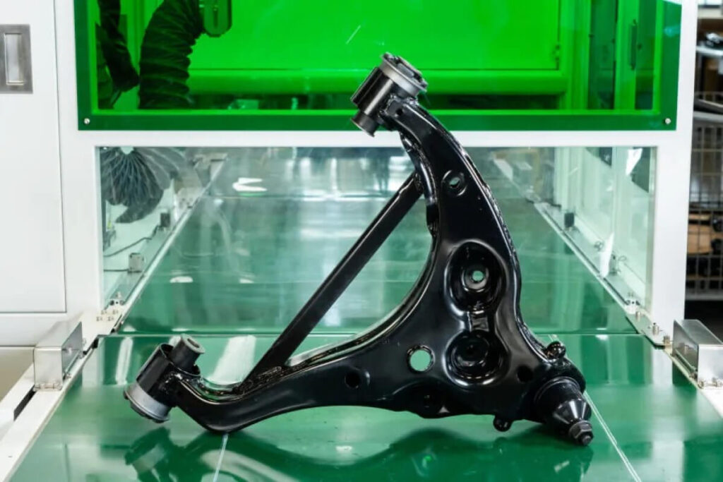 This image shows a control arm assembly ready for packaging at the SH Autoparts manufacturing facility in Taiwan